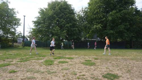 Uczestnicy gry na boisku trawiastym.