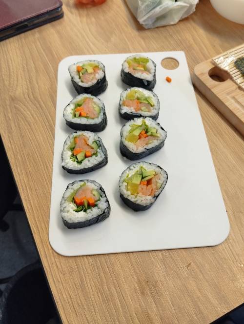 Kawałki sushi przygotowane przez uczestników na desce.