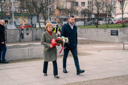 Posłanka M. Kołodziejczak oraz senator R. Świlski składają kwiaty pod pomnikiem Nike.