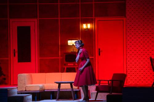 Kobieta w czerwonej sukience na scenie.