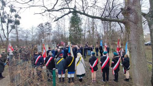 Widok na zebranych gości zza pleców  pocztów sztandarowych.