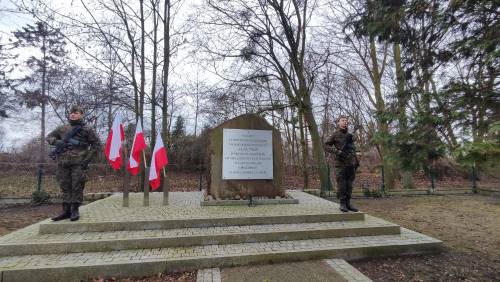 Pomnik przy ul. Powstańców Warszawy - po bokach stoją żołnierze z brodnią.