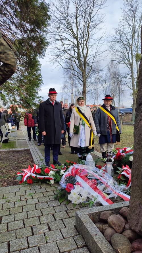 Goście uroczystości składają kwiaty pod pomnikiem przy ul. Powstańców Warszawy.