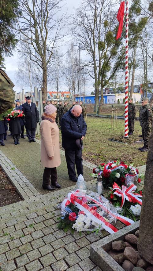 Goście uroczystości składają kwiaty pod pomnikiem przy ul. Powstańców Warszawy.