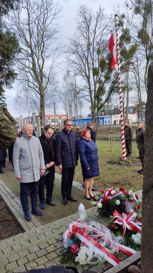 Goście uroczystości składają kwiaty pod pomnikiem przy ul. Powstańców Warszawy – w środku kadru Burmistrz Pruszcza Gdańskiego Janusz Wróbel.