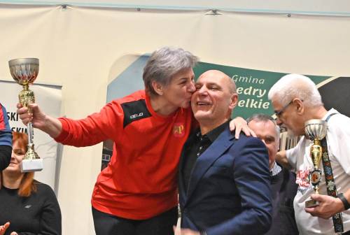 Kobieta- reprezentantka drużyny zwycięzców odbiera puchar i całuje starostę.