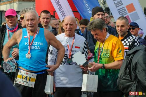 Grupa mężczyzna z medalami i upominkami.