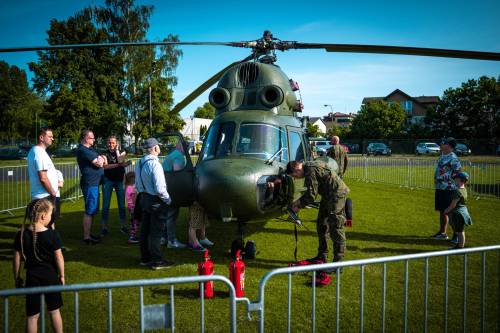 Helikopter na trawie i ludzie oglądający pojazd