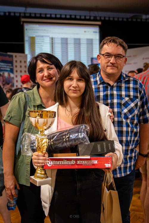 Zwyciężczyni mistrzostw z pucharem w ręku w towarzystwie dwóch osób