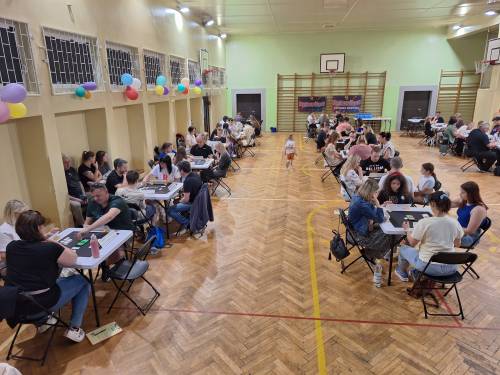 Rozgrywki Rummikub, zawodnicy siedzą przy stolikach