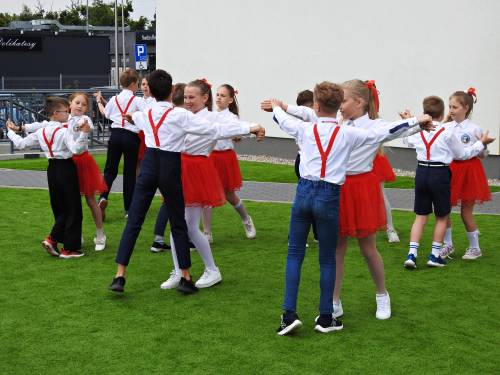 Dzieci w biało-czerwonych strojach tańczą walca