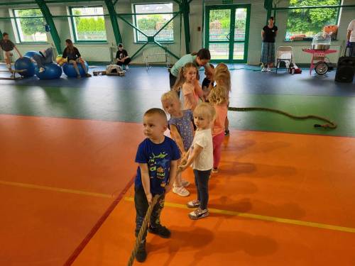 Dzieci w hali sportowej trzymają linę do przeciągania