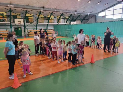 Dzieci ustawione w trzech rzędach w hali sportowej