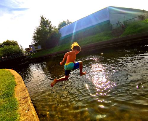 Chłopiec skacze do wody.