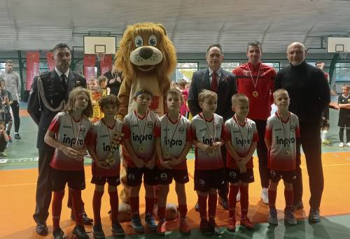 Na zdjęciu stoi obok siebie grupa osób, nagrodzonych za udział w turnieju piłki nożnej