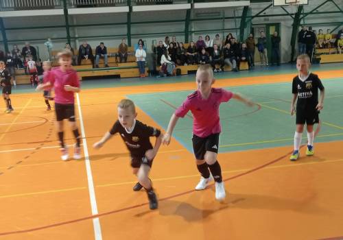 Zdjęcie przedstawia dynamiczną scenę meczu piłki nożnej halowej