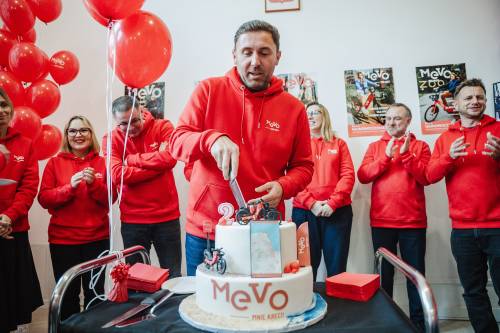 Uroczystość, czerwone stroje, mężczyzna kroi tort.