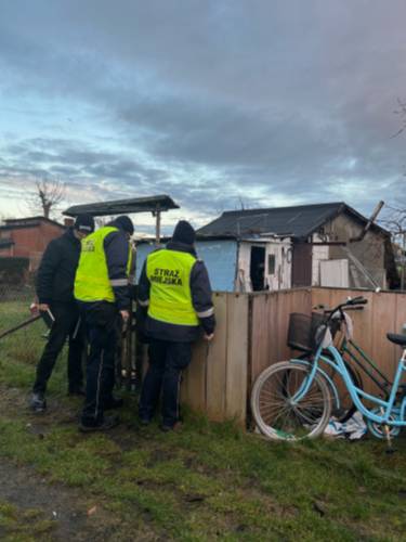 Trzy postacie przy ogrodzeniu