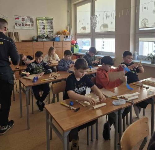 Uczniowie budują karmnik podczas zajęć