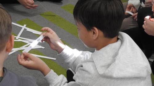 Dziecko trzyma karteczkę z zapisanym zdaniem