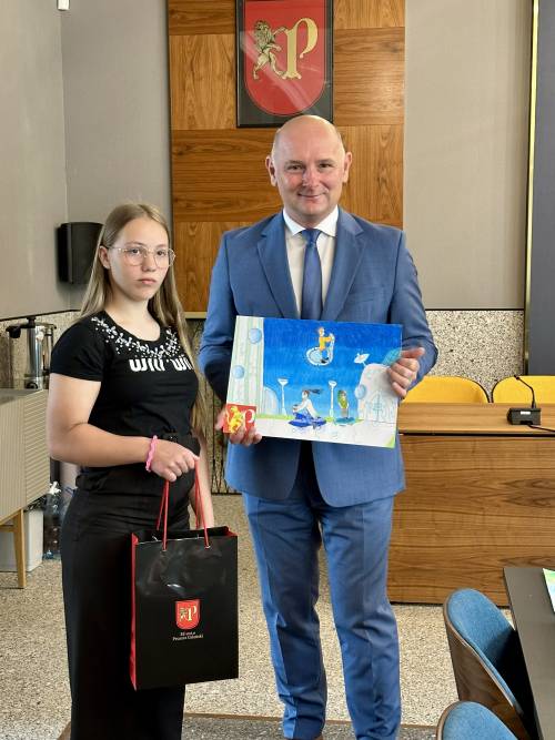 Zastępca burmistrza z nagrodzona pracą, obok niego stoi jedna z laureatek