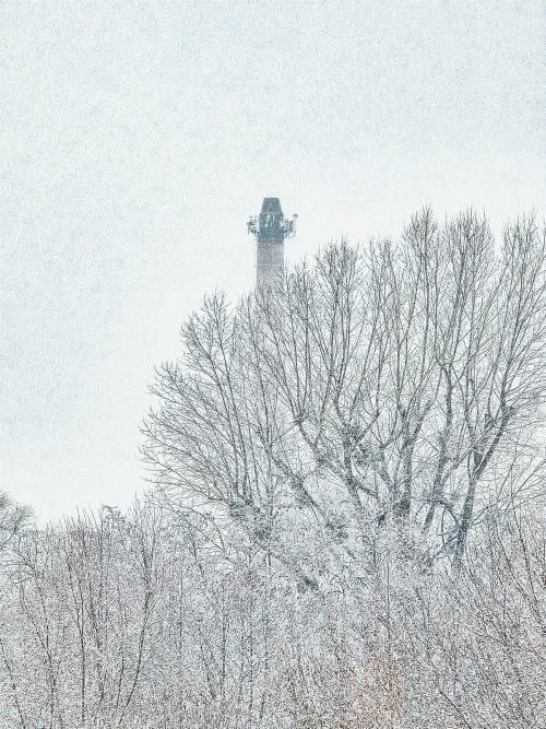 Ośnieżone drzewa i czubek komina cukrowni