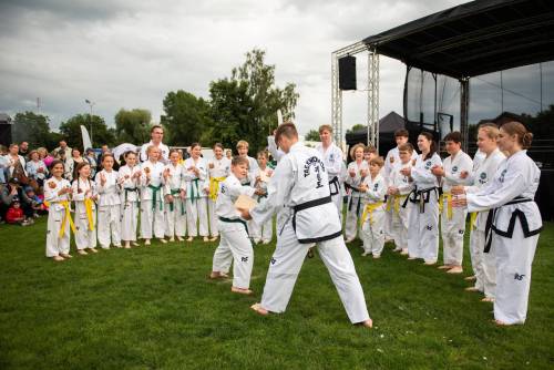 Dwóch zawodników teakwon-do walczy w otoczeniu innych zawodników