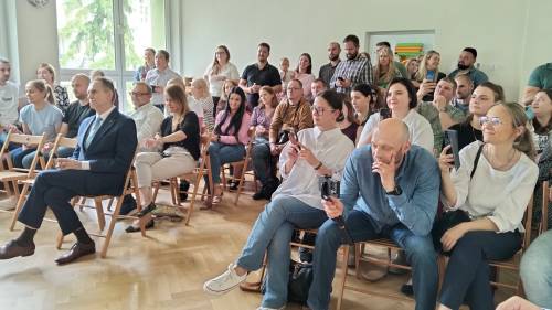 Grupa rodziców i zastępca burmistrza siedzą na krzesełkach