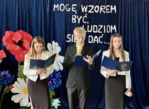 Dwie uczennice i uczeń trzymają w rękach teczki