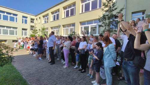 Grupa rodziców nagrywająca telefonami uczniów