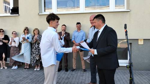 Nauczyciel wręcza uczniowi dyplom