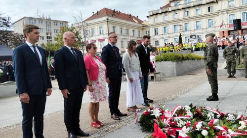 Grupa samorządowców stoi przed pomnikiem