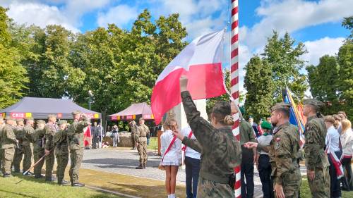 Żołnierze wciągają biało-czerwoną flagę na maszt