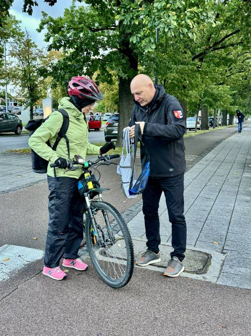 Mężczyzna wręcza rowerzystce torbę z gadżetami